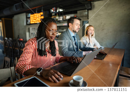 Diverse business professionals working remote in coffee shop 137811151