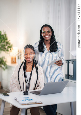 Two black women smiling confident in modern office 137811152