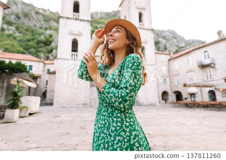 Happy female tourist in beautiful dress walking in the street of the city. Fashion style. Happy female tourist in beautiful dress walking in the street of the city. Fashion style. 137811260