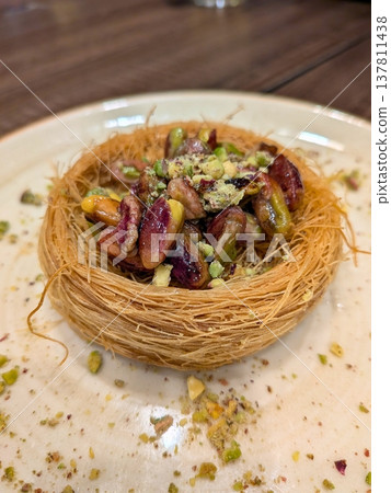 Pistachio birds nest kunafa dessert on white plate 137811438