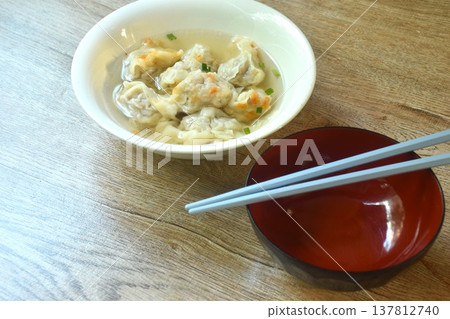 Chinese dumpling topping slice red barbecue pork with clear soup on bowl 137812740