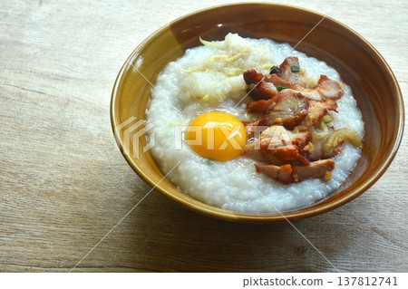 congee or rice porridge soup topping sweet red barbecue pork and egg yolk on bowl congee or rice porridge soup topping sweet red barbecue pork and egg yolk on bowl 137812741