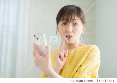 60多歲的女性經營智能手機 60多歲的女性經營智能手機 137812784