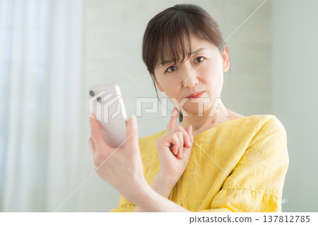 60多歲的女性經營智能手機 60多歲的女性經營智能手機 137812785