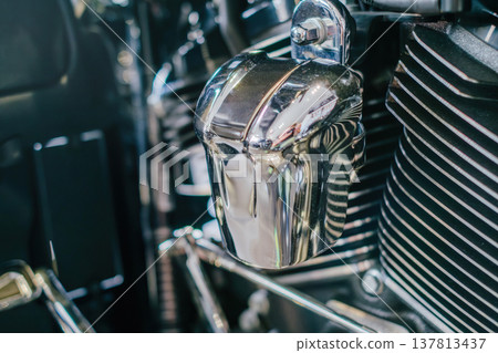 A detailed macro shot focusing on the shiny chrome surfaces and cooling fins of a motorcycle engine, capturing sharp reflections and metallic textures. A detailed macro shot focusing on the shiny chrome surfaces and cooling fins of a motorcycle engine, capturing sharp reflections and metallic textures. 137813437