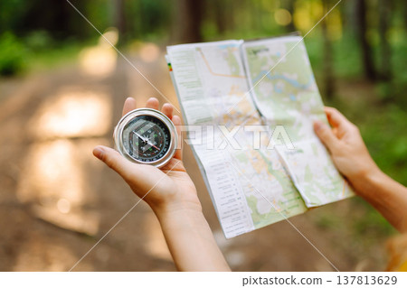 Exploring the forest with a map and compass during a sunny afternoon in a tranquil wooded area 137813629