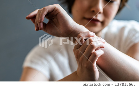 一名女子正在撫摸自己的手腕。 137813663