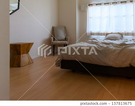 A bright bedroom and a wooden side table 137813675