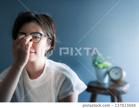 一位女士正在調整眼鏡的肖像 137813688