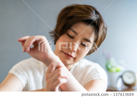 The woman's face as she gently touches the wristband. The woman's face as she gently touches the wristband. 137813689