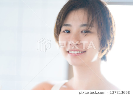 一位短髮女子在明亮的陽光下微笑。 137813698