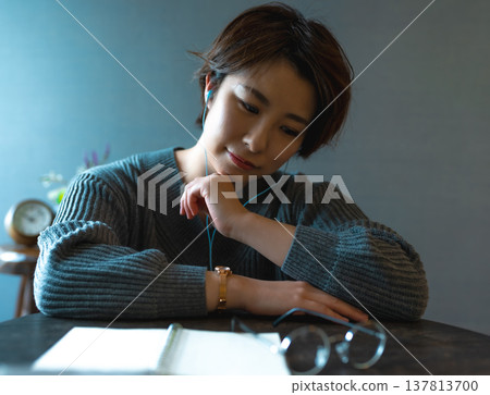 Women listening to music with earphones Women listening to music with earphones 137813700