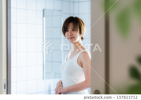 一位短髮女子在浴室裡微笑。 一位短髮女子在浴室裡微笑。 137813712