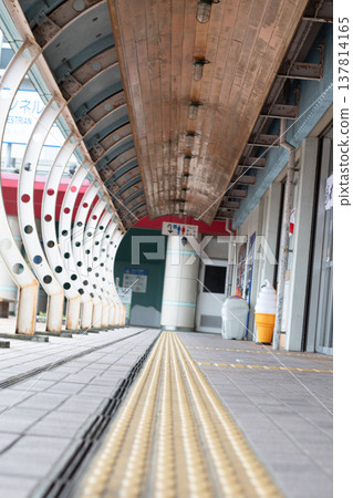 A typical Japanese scene featuring deep, arched walkways and tactile paving blocks. 137814165