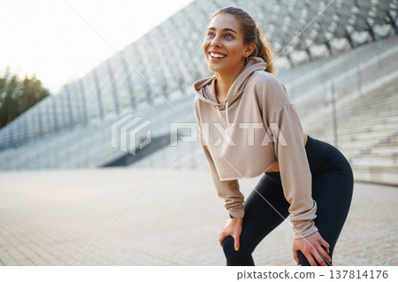 Athletic young woman training outdoors. Fitness woman stretching outdoors. Active lifestyle. Athletic young woman training outdoors. Fitness woman stretching outdoors. Active lifestyle. 137814176