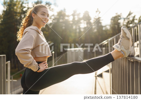 Athletic young woman training outdoors. Fitness woman stretching outdoors. Active lifestyle. 137814180
