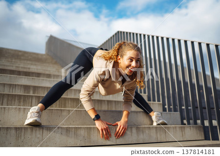 Athletic young woman training outdoors. Fitness woman stretching outdoors. Active lifestyle. 137814181