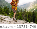 Close-up of female legs in hiking boots on a hiking trail. Travel, vacation. The concept of nature. 137814740
