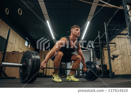 No pain, no gain, weightlifting. Athletic man is with a barbell in a gym 137814820