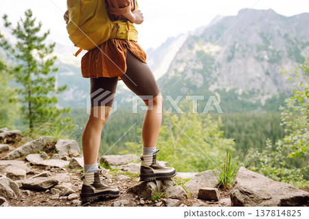 Close-up of female legs in hiking boots on a hiking trail. Travel, vacation. The concept of nature. Close-up of female legs in hiking boots on a hiking trail. Travel, vacation. The concept of nature. 137814825