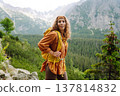 Young traveler woman with a yellow backpack on a cliff. Sports concept, traveler. Active lifestyle. 137814832