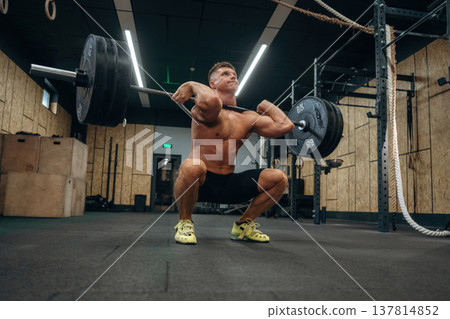 No pain, no gain, weightlifting. Athletic man is with a barbell in a gym 137814852
