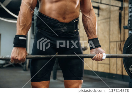 Strength and stamina. Close up view of athletic man that is lifting heavy barbell Strength and stamina. Close up view of athletic man that is lifting heavy barbell 137814878