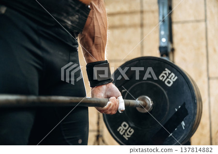 Close up view of athletic man that is lifting heavy barbell 137814882