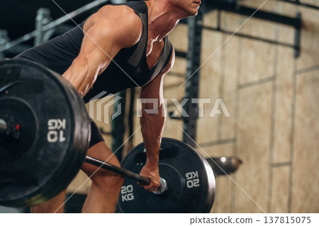Close up view of athletic man that is lifting heavy barbell 137815075