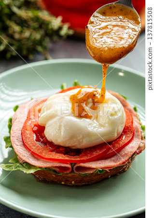 Poached egg sandwich with ham and sauce 137815508