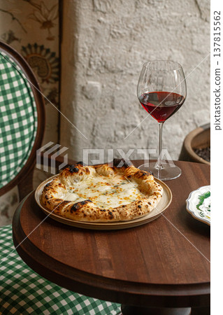 Four cheese pizza with red wine on table Four cheese pizza with red wine on table 137815562