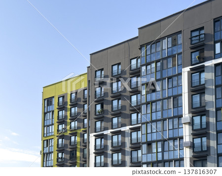 Modern apartment building facade in urban residential area. Colorful green and gray exterior with 137816307