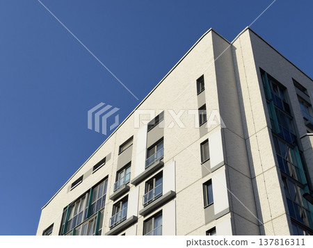 Modern apartment building facade in urban residential area. White brick exterior with glass windows 137816311