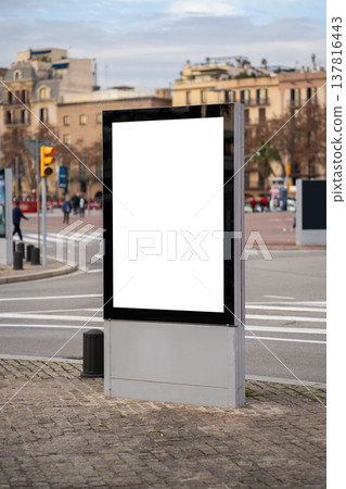 Blank vertical digital screen display standing on a city street corner, offering ample advertising space for marketing campaigns and public information in an urban environment Blank vertical digital screen display standing on a city street corner, offering ample advertising space for marketing campaigns and public information in an urban environment 137816443