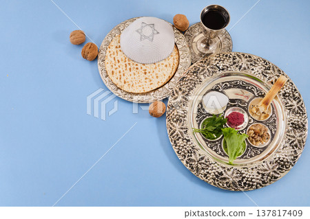 Passover seder plate with matzah, kippah, and wine 137817409
