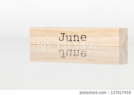 a wooden cube with the inscription June on a white background a wooden cube with the inscription June on a white background 137817459