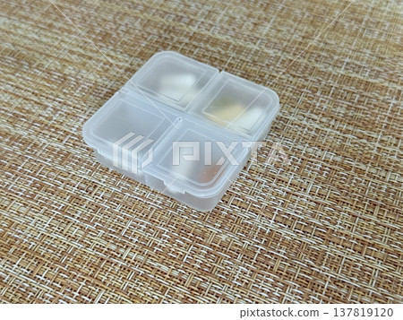 The weekly transparent pillbox is designed for convenient and efficient daily storage of dietary supplements and tablets. It has compartments with various types of capsules for administration. 137819120