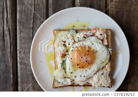 Open-faced sandwich with potato salad drizzled in olive oil and a fried egg. Open-faced sandwich with potato salad drizzled in olive oil and a fried egg. 137819252
