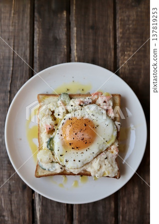 Open-faced sandwich with potato salad drizzled in olive oil and a fried egg. Open-faced sandwich with potato salad drizzled in olive oil and a fried egg. 137819253