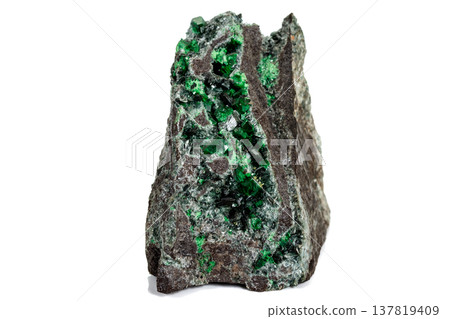 Macro stone garnet mineral, Uvarovite in rock on a white background 137819409