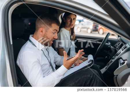 Man is mad, disappointed. Woman is with instructor in car, driving school concept Man is mad, disappointed. Woman is with instructor in car, driving school concept 137819566