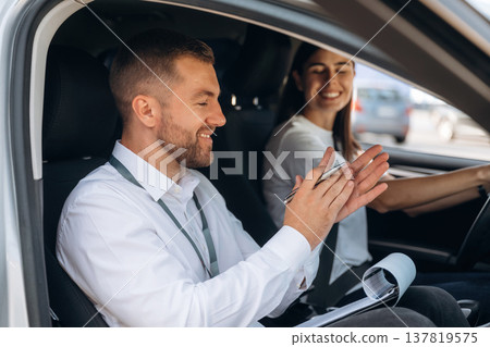 Positive mood, smiling. Woman is with instructor in car, driving school concept 137819575