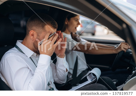 Man is mad, disappointed. Woman is with instructor in car, driving school concept Man is mad, disappointed. Woman is with instructor in car, driving school concept 137819577