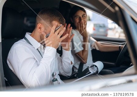 Man is mad, disappointed. Woman is with instructor in car, driving school concept Man is mad, disappointed. Woman is with instructor in car, driving school concept 137819578