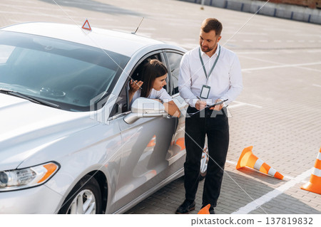 Hit the cones. Woman is trying to pass exam in the driving school 137819832