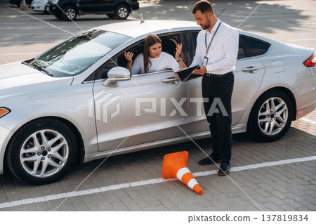 Hit the cones. Woman is trying to pass exam in the driving school Hit the cones. Woman is trying to pass exam in the driving school 137819834