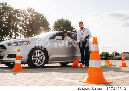 By the guidance of man. Woman is trying to pass exam in the driving school By the guidance of man. Woman is trying to pass exam in the driving school 137819840