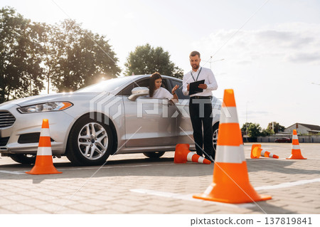 Hit the cones. Woman is trying to pass exam in the driving school Hit the cones. Woman is trying to pass exam in the driving school 137819841