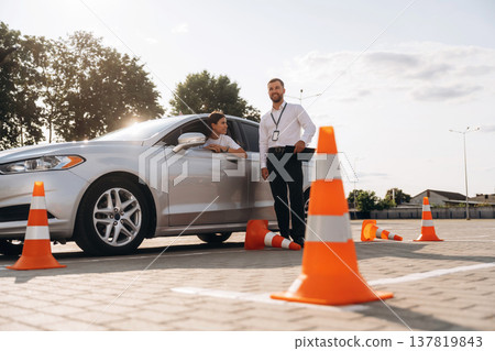 Hit the cones. Woman is trying to pass exam in the driving school Hit the cones. Woman is trying to pass exam in the driving school 137819843