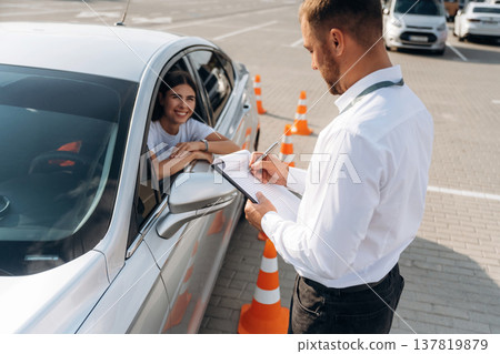 Using pen and writing results into notepad. Woman is trying to pass exam in the driving school 137819879